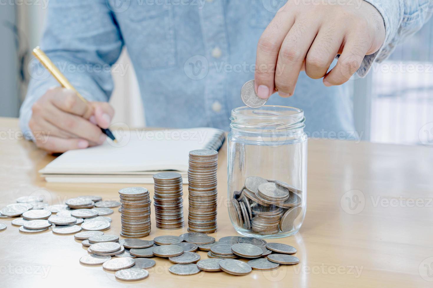 Ahorro de dinero mano de hombre poniendo una moneda en una jarra concepto de vidrio finanzas empresariales foto