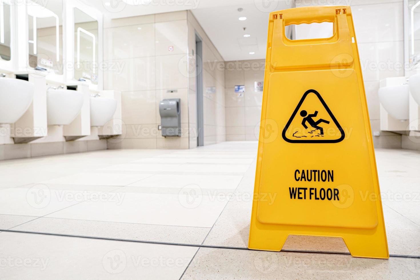 Yellow slippery warning sign, caution wet floor sign in the toilet room photo