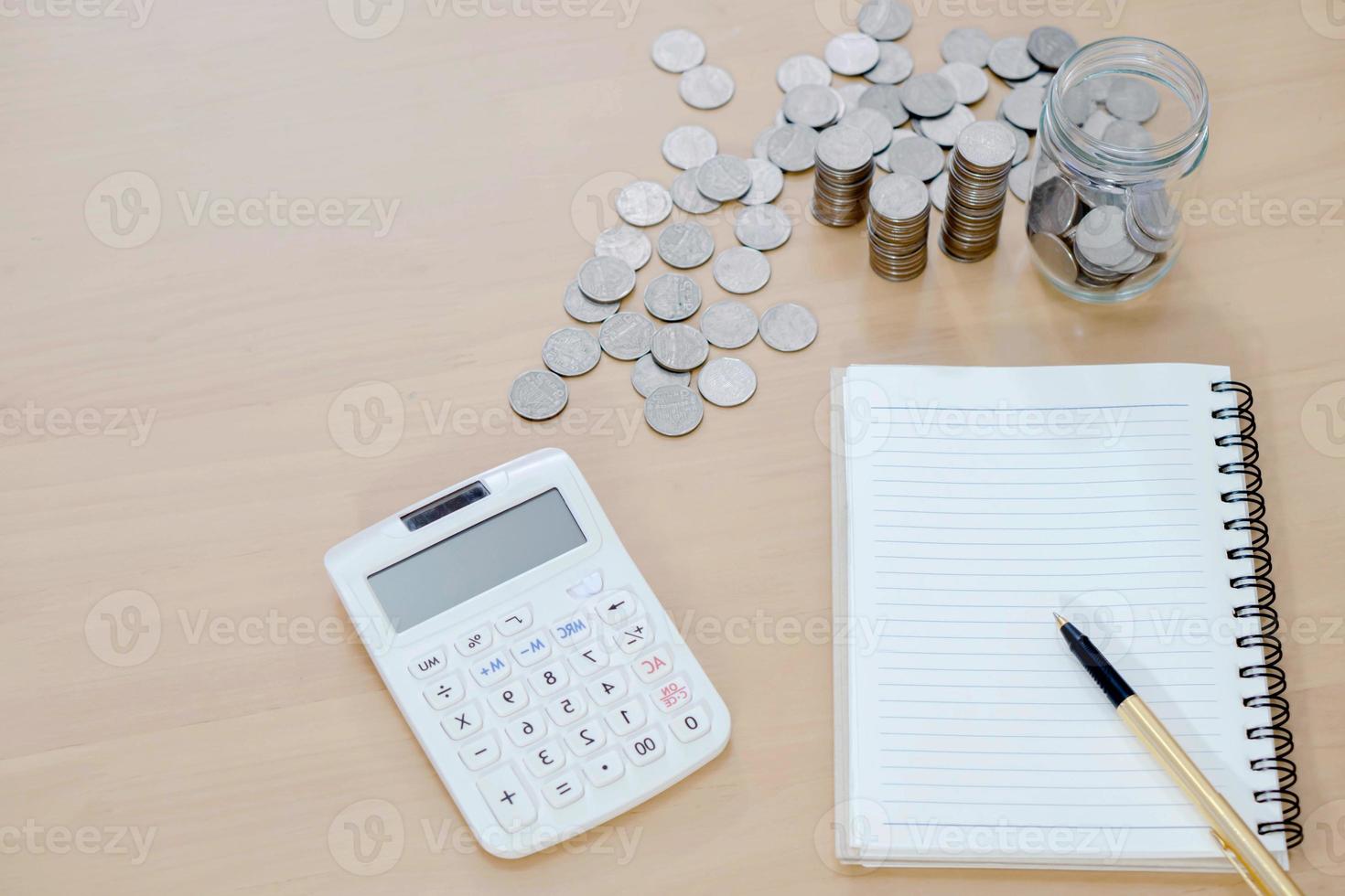 Office Note Book, Calculator, Coins and Pen photo