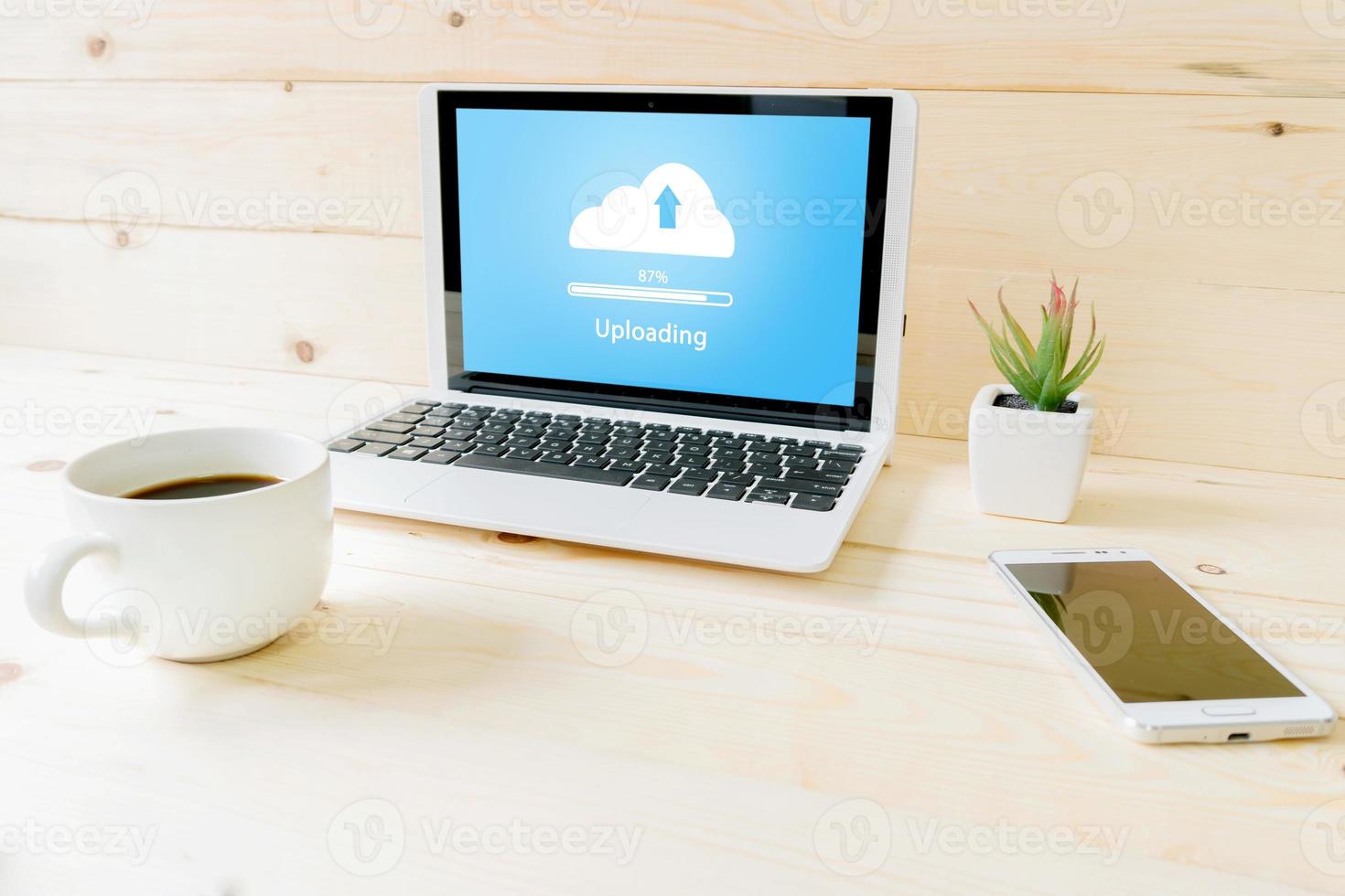 Cloud uoloading on laptop  on wood table photo