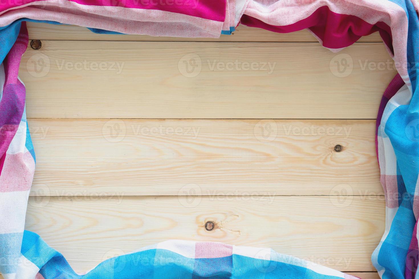 Checkered fabric on wood table background. photo