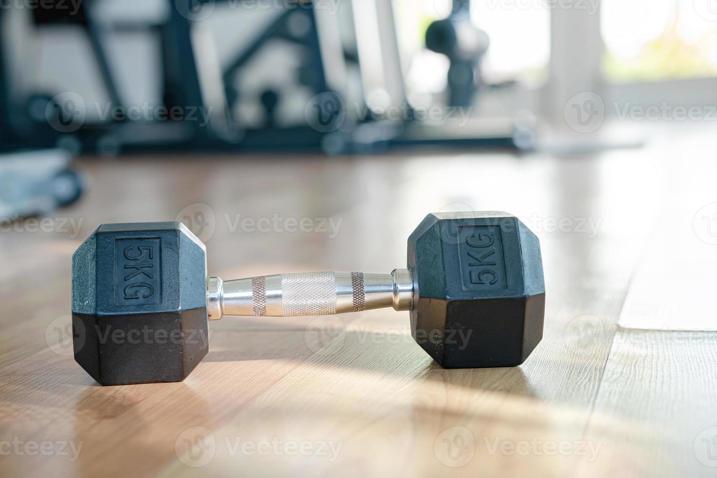 Close-up of dumbbells on the floor of home gym with sunlight through the window photo