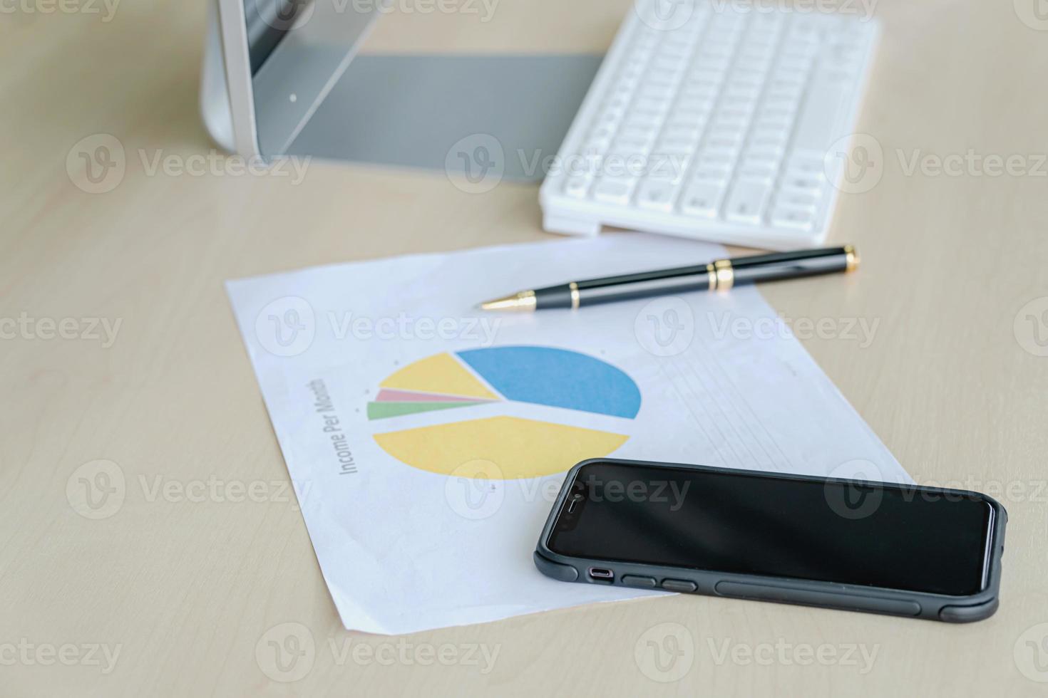 Office desk with monitors keyboards Mobile and the different graphs on paper. photo