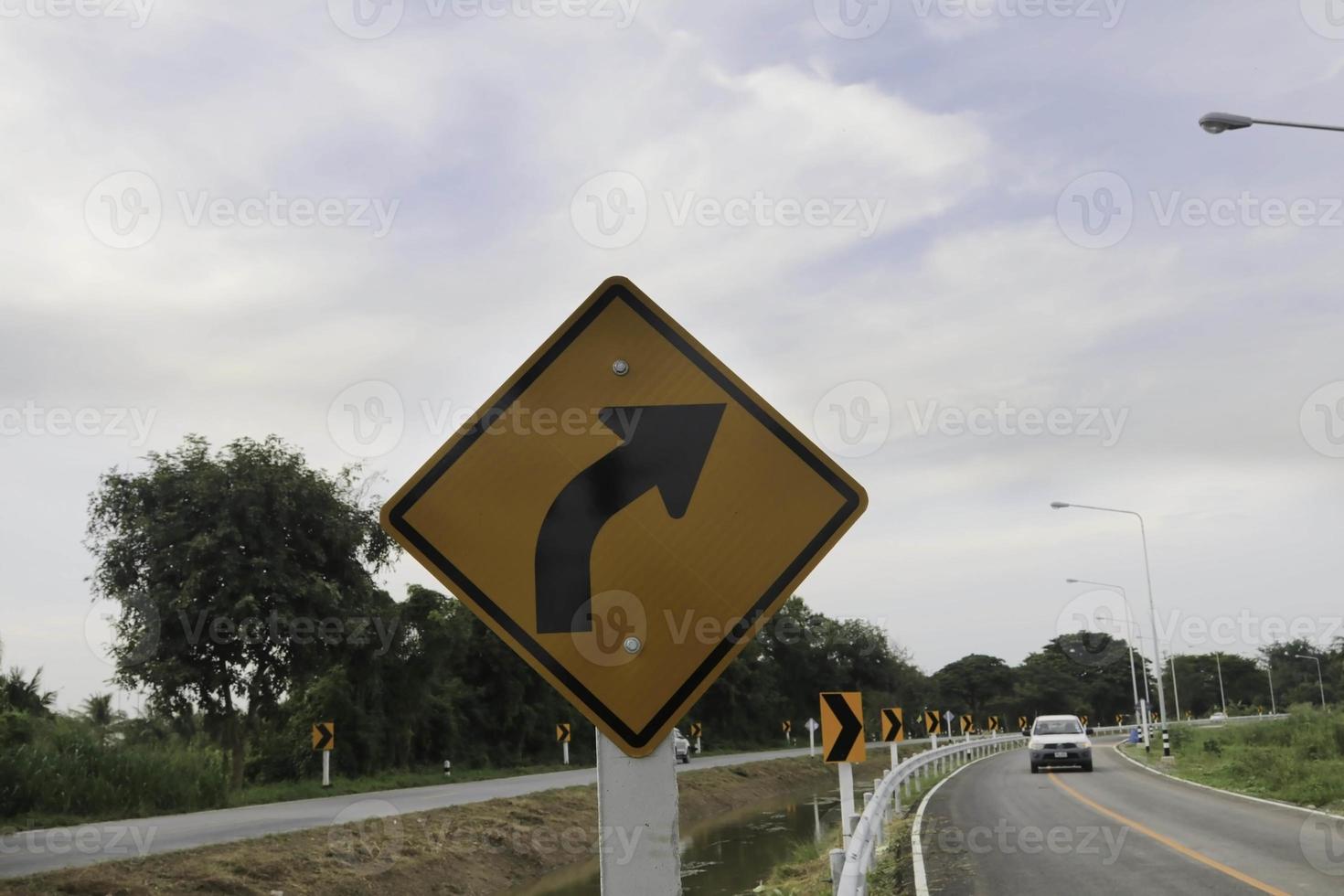 gire a la izquierda con un cartel para conducir, tenga cuidado con las curvas y las velocidades lentas por su propia seguridad, ya que puede haber un accidente en cualquier momento. foto