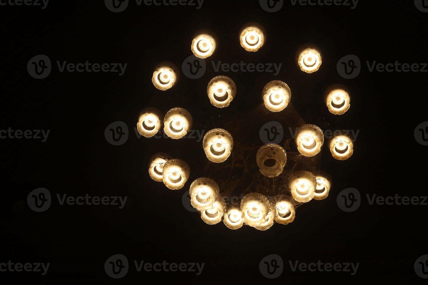 Photo of dark grunge room interiors with wooden floors and chandelier. The black and yellow background of the home lighting are decorated in a modern yet classic decor.