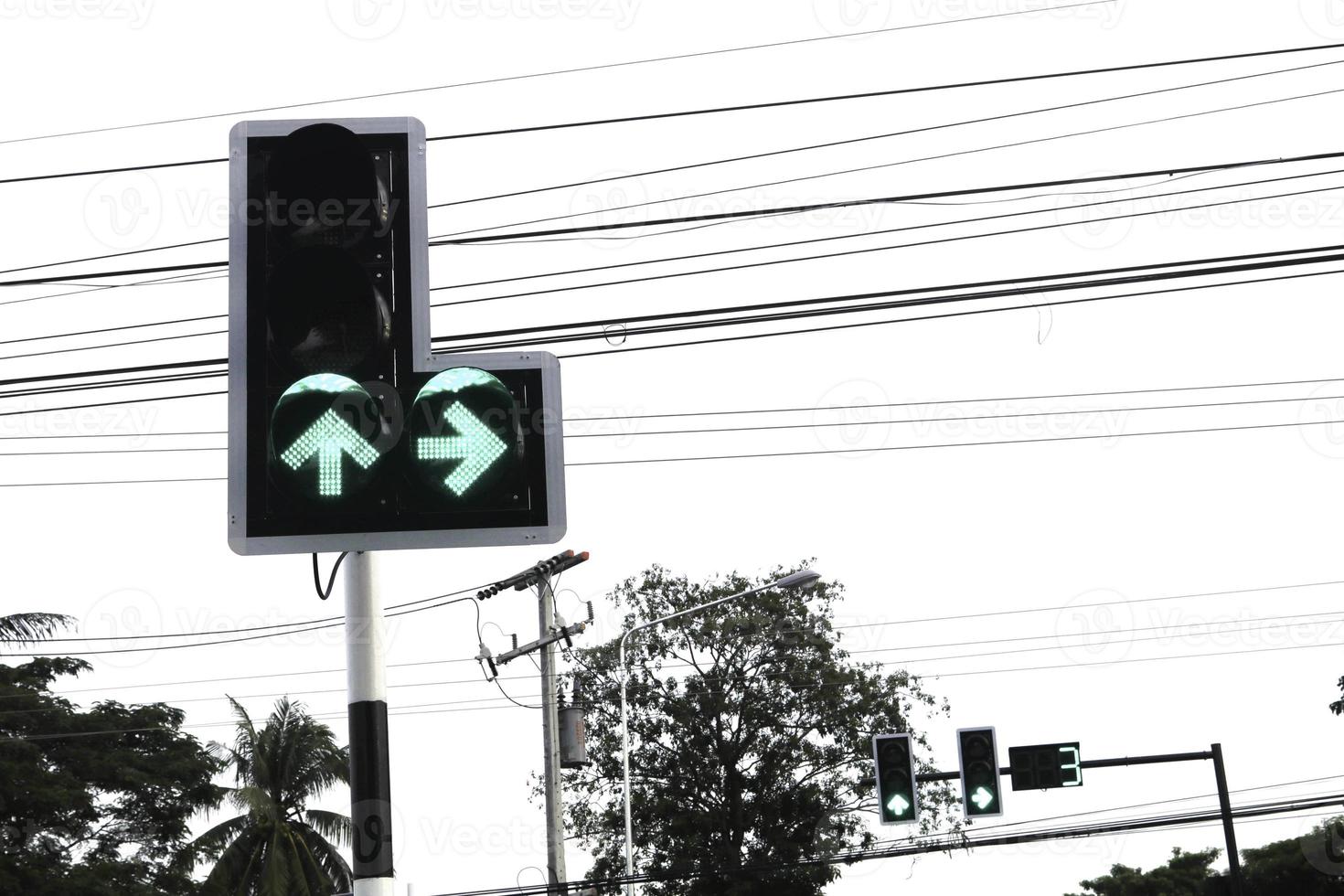 At the intersection, green and red lights are a sign of going straight or turning left and white - or stopping driving. Be careful and respect traffic rules. photo