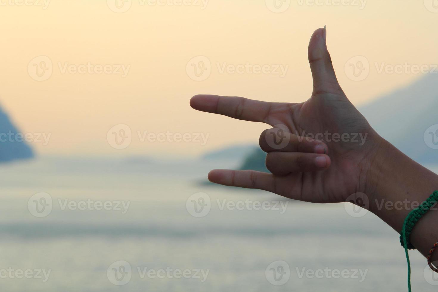 Three finger symbol The mother finger, the index finger and the little finger symbolize love and peace on the mountains, rivers and the blue background is a land full of tourists. photo