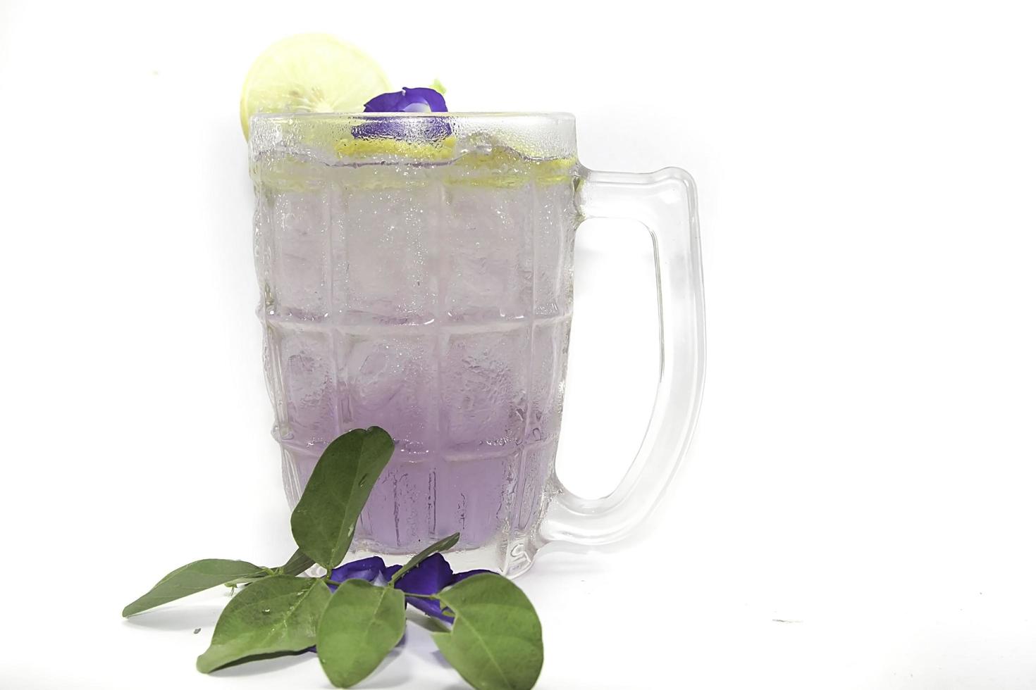 Purple Butterfly Pea Flower Water or Butterfly Pea Flower Tea with Honey and Lemon is a healthy herbal water with beta-carotene on a white background. photo