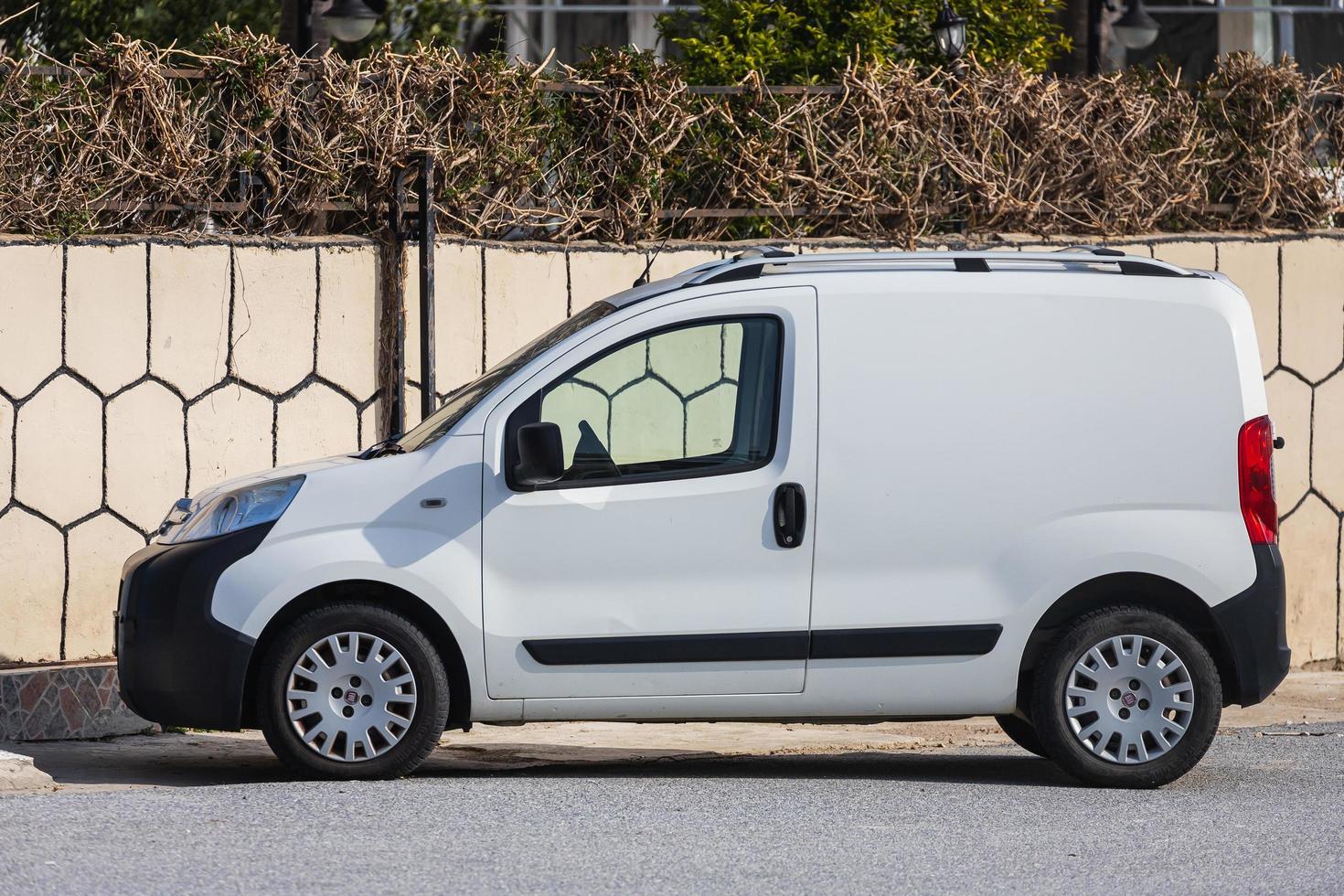 lado turquía 18 de febrero de 2022 fiat fiorino blanco está estacionando en la calle en un día de verano contra el telón de fondo de una cerca, parque foto