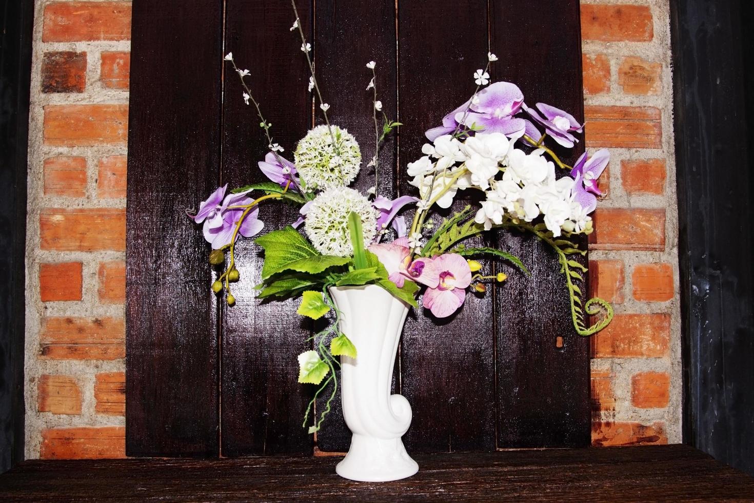 Vases and flowers on the background, dark brown wood panels and red brick walls that are located in the cafes' doors decorated in an old-fashioned style. photo