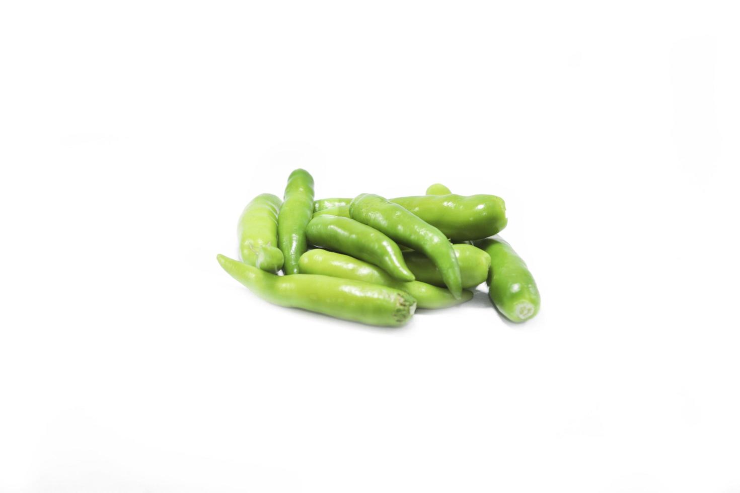 Fresh large green chillies cultivated by farmers for sale and self-eating - for seasoning and appetizing food on a white background with local hot letters. photo