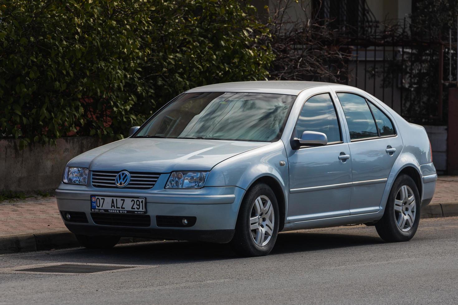 Side  Turkey   February 20 2022 silver Volkswagen Bora   is parked  on the street on a warm  day against the backdrop of a buildung, trees, fence photo