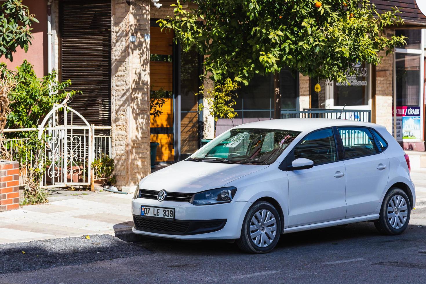 Side Turkey  February 20 2022   white   Volkswagen Polo is parked  on the street on a warm day against the backdrop of  shops photo