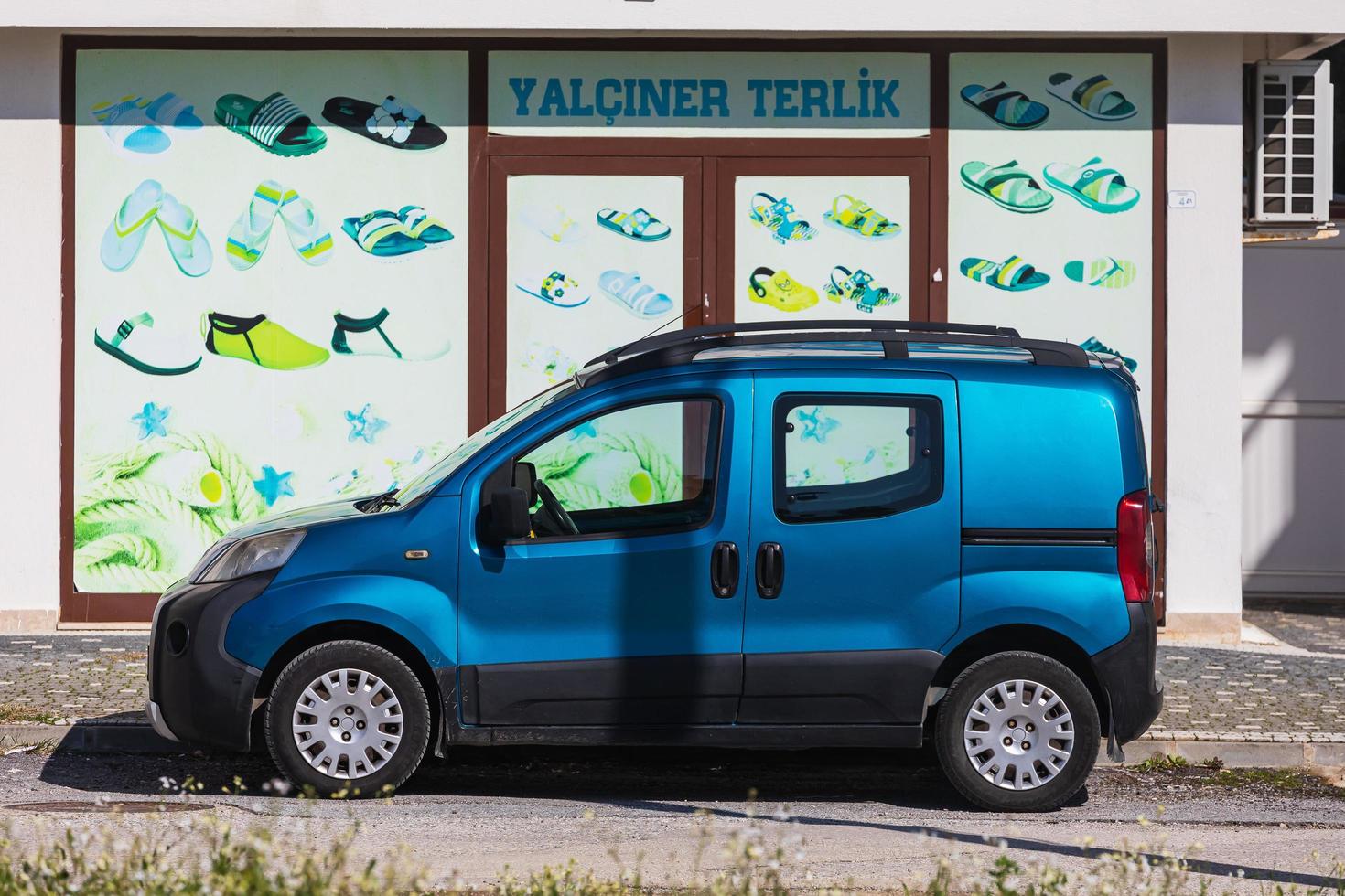 Side Turkey  March 01 2022   blue Fiat Fiorino is parking  on the street on a  summer day against the backdrop of a shop photo