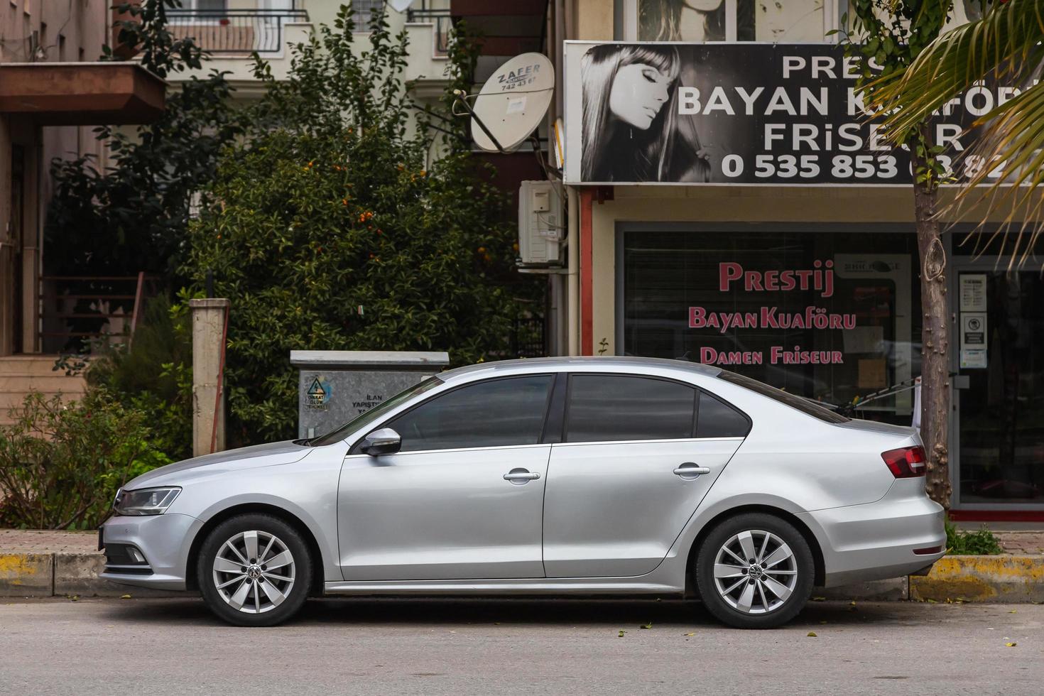 lado turquía 20 de febrero de 2022 volkswagen passat blanco está estacionado en la calle en un cálido día de otoño con el telón de fondo de una calle, tienda foto