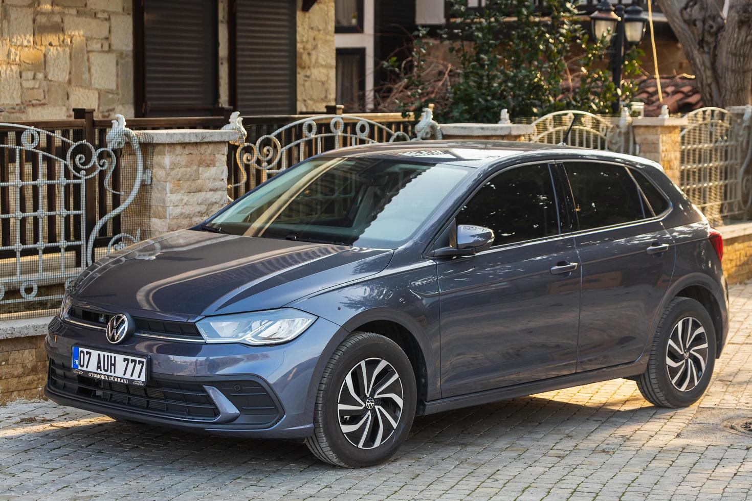 Side  Turkey  February 18 2022  gray Volkswagen Golf  is parked  on the street on a summer day against the backdrop of a buildung, trees, shops photo