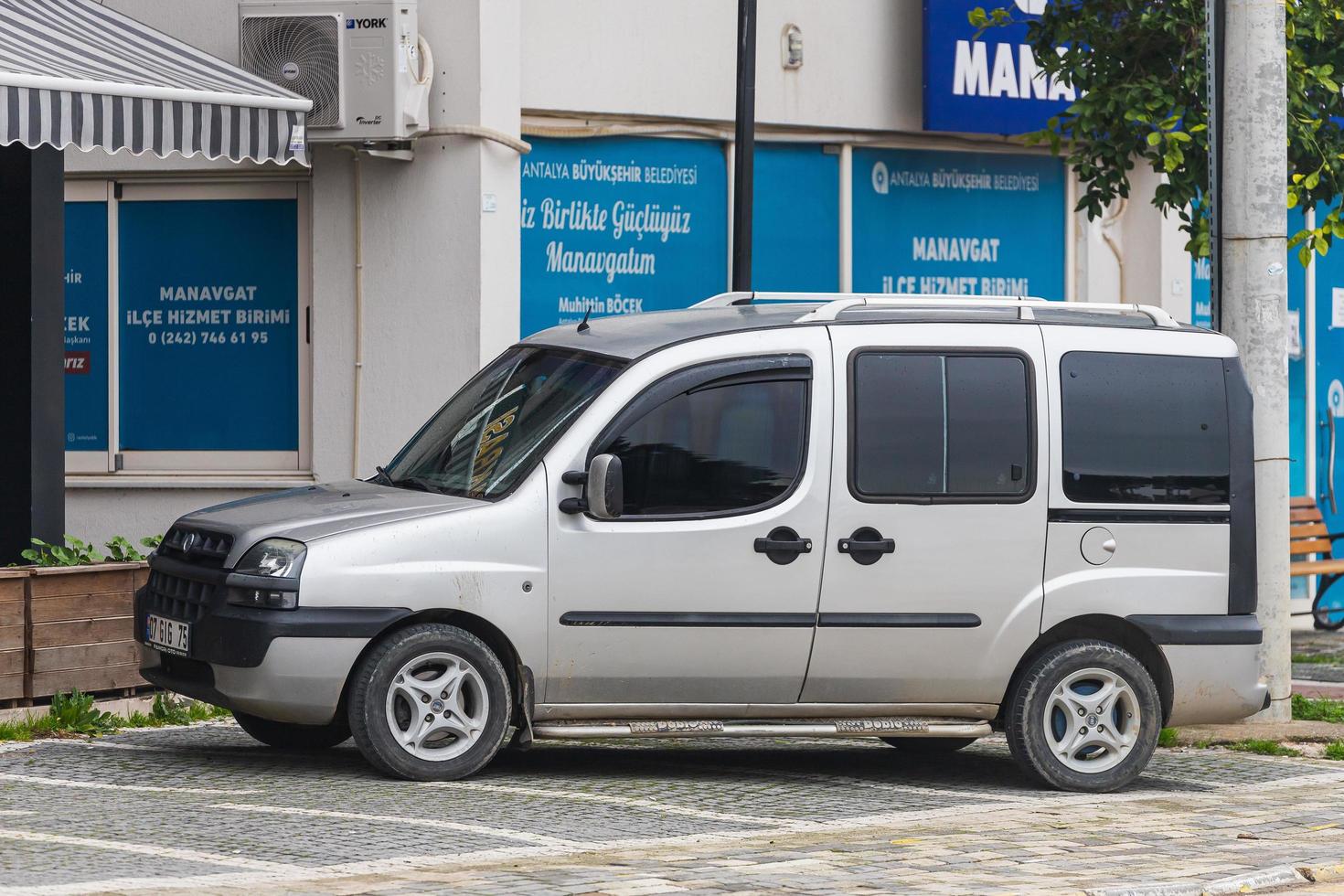 Side Turkey  March 03 2022   silver  Fiat Doblo   is parked  on the street on a warm summer day against the   parking photo
