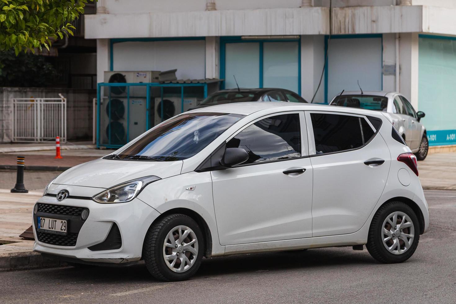 Side  Turkey  February  20, 2022  white   Hyundai i10  is parking  on the street on a  summer day against the backdrop of a shop photo