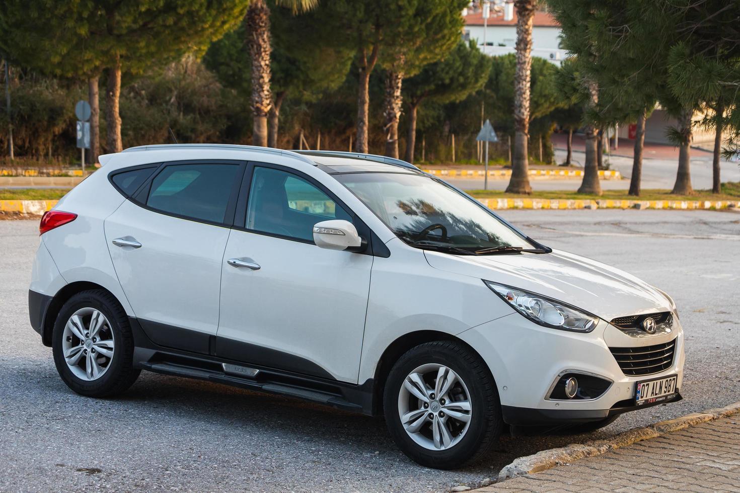 lado turquía 18 de febrero de 2022 el hyundai ix35 blanco está estacionado en la calle en un cálido día de verano con el telón de fondo de un parque foto