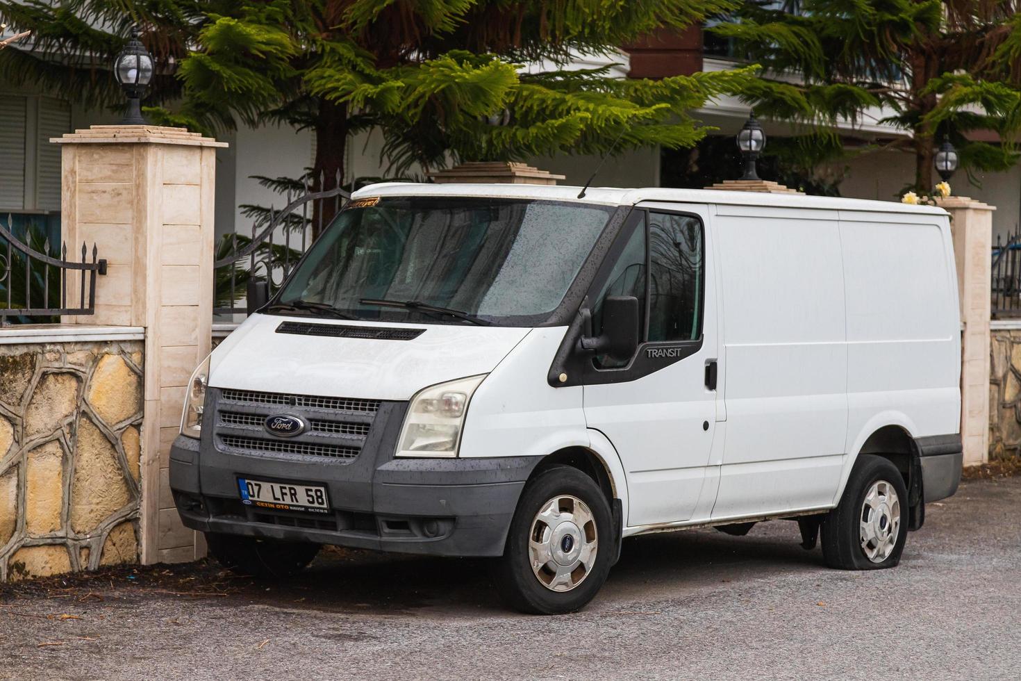 lado turquía 03 de marzo de 2022 el maletero blanco ford transit está estacionando en la calle en un día de verano foto