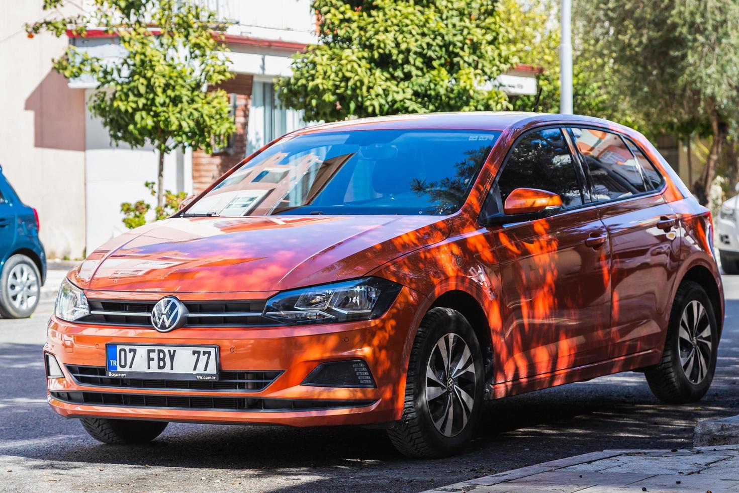 Side Turkey  February 20 2022  orange   Volkswagen Polo is parked  on the street on a warm day against the backdrop of  park photo