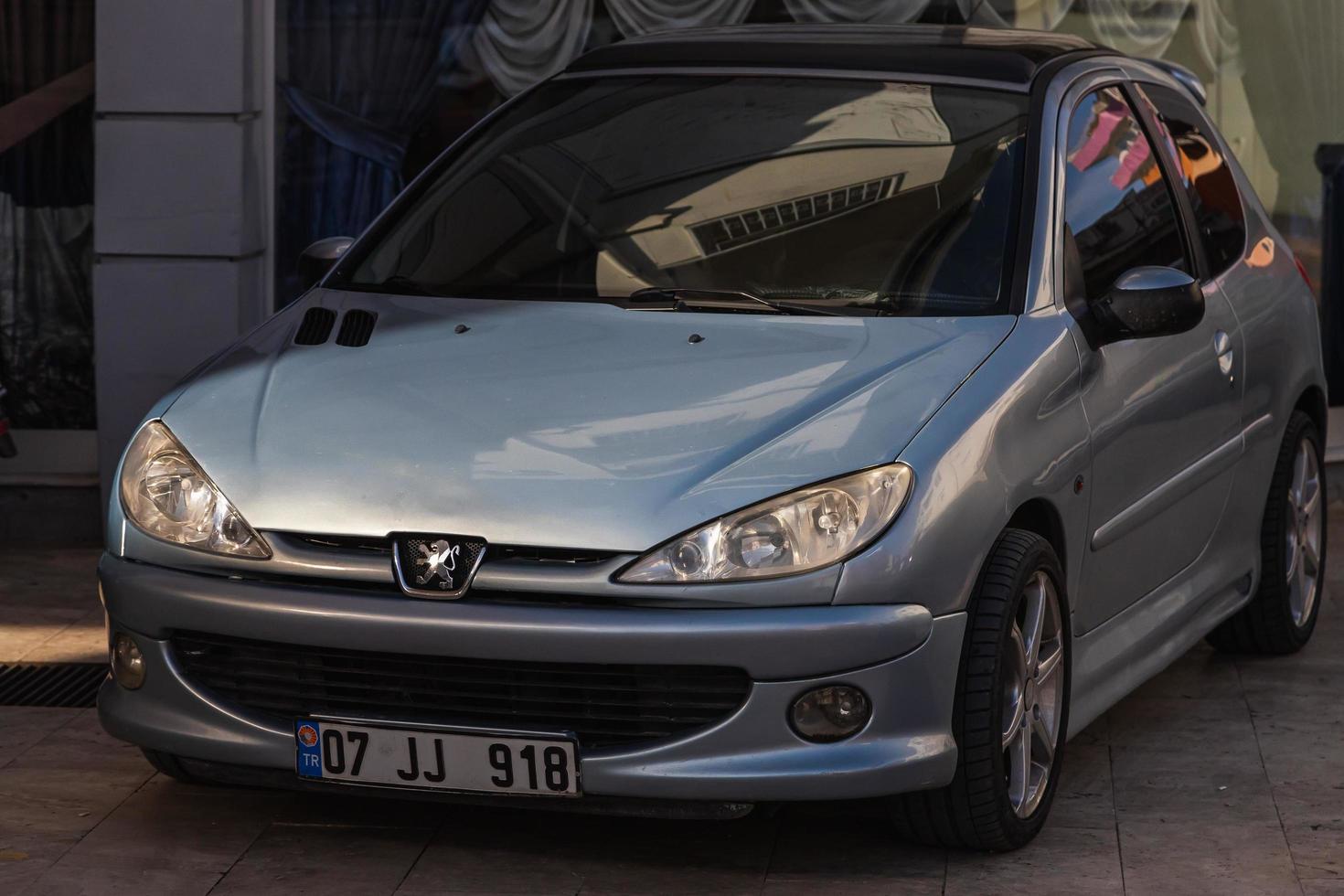 Side Turkey  February 20  2022    silver  Peugeot 208  is parked  on the street on a warm summer day against the backdrop of a building photo