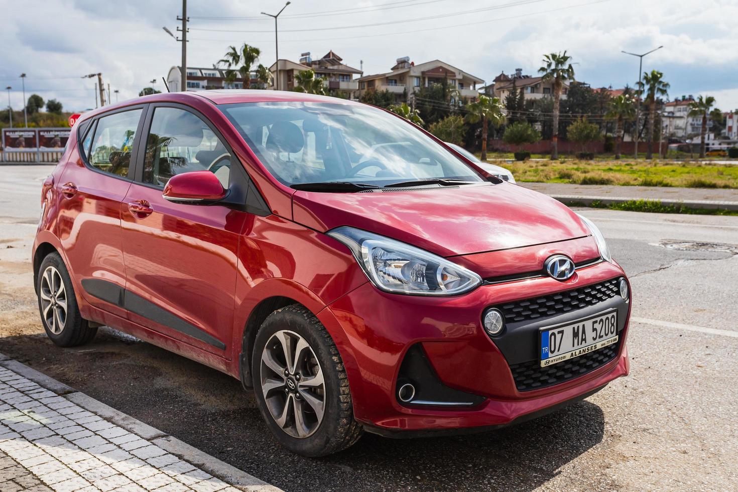 Side Turkey  February 28 2022  red  Hyundai i10  is parking  on the street on a  summer day against the backdrop of a park photo
