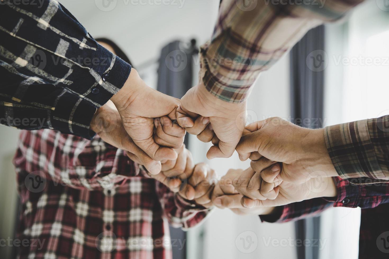 young business people putting their hands together photo