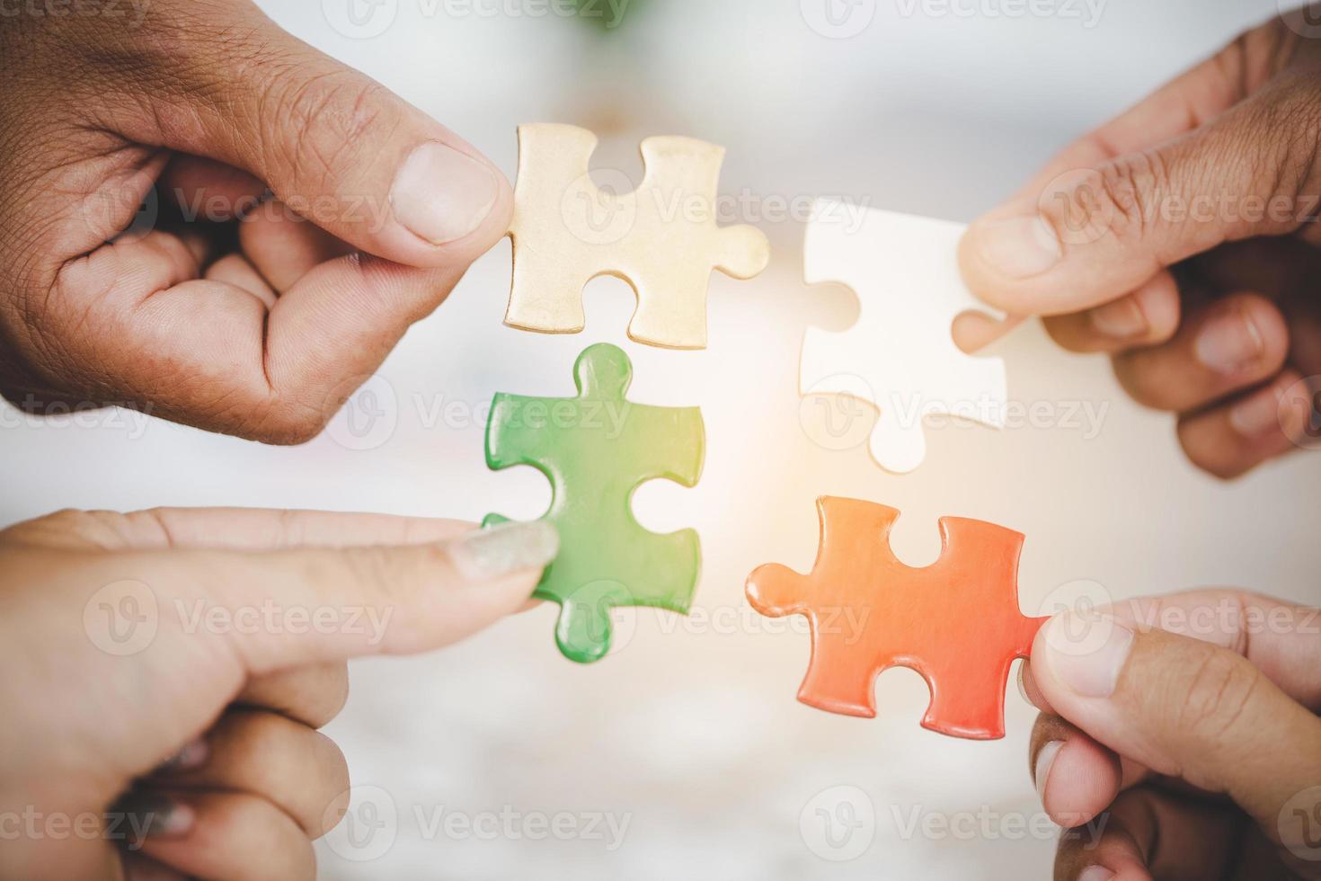 Hands holding piece of blank jigsaw puzzle for teamwork photo