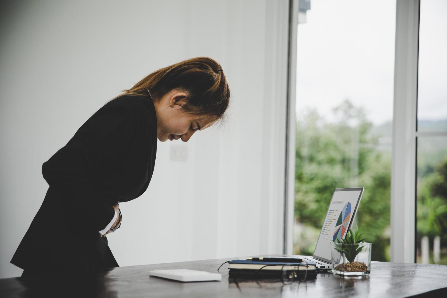 young business woman suffering from stomach pain photo