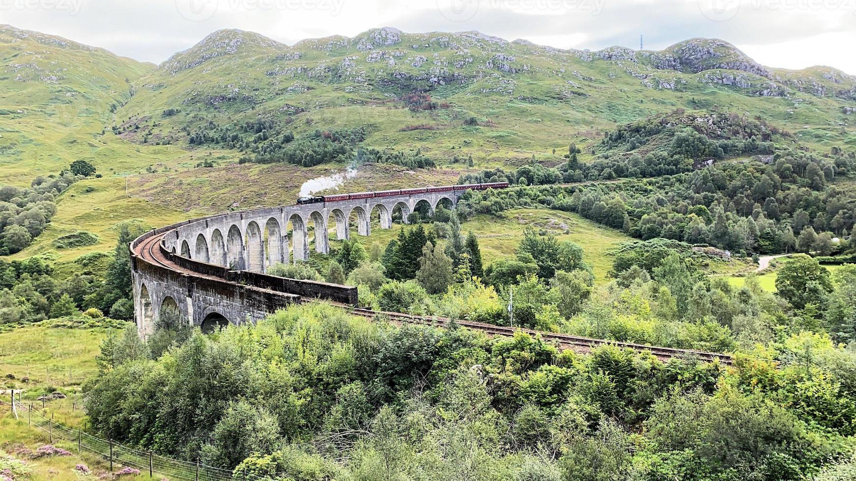 A view of the Glenfinnan Viaduct showing a Steam Train passing over it photo