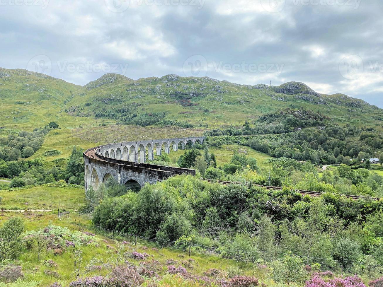 A view of the Glenfinnan Viaduct showing a Steam Train passing over it photo