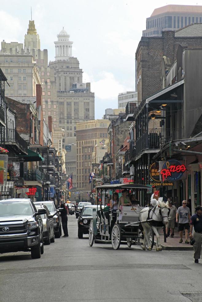 12 April 2018 - New Orleans, Louisiana, United States - Street scene in the French Quarter of New Orleans, Louisiana, with the higher downtown buildings in the background. photo