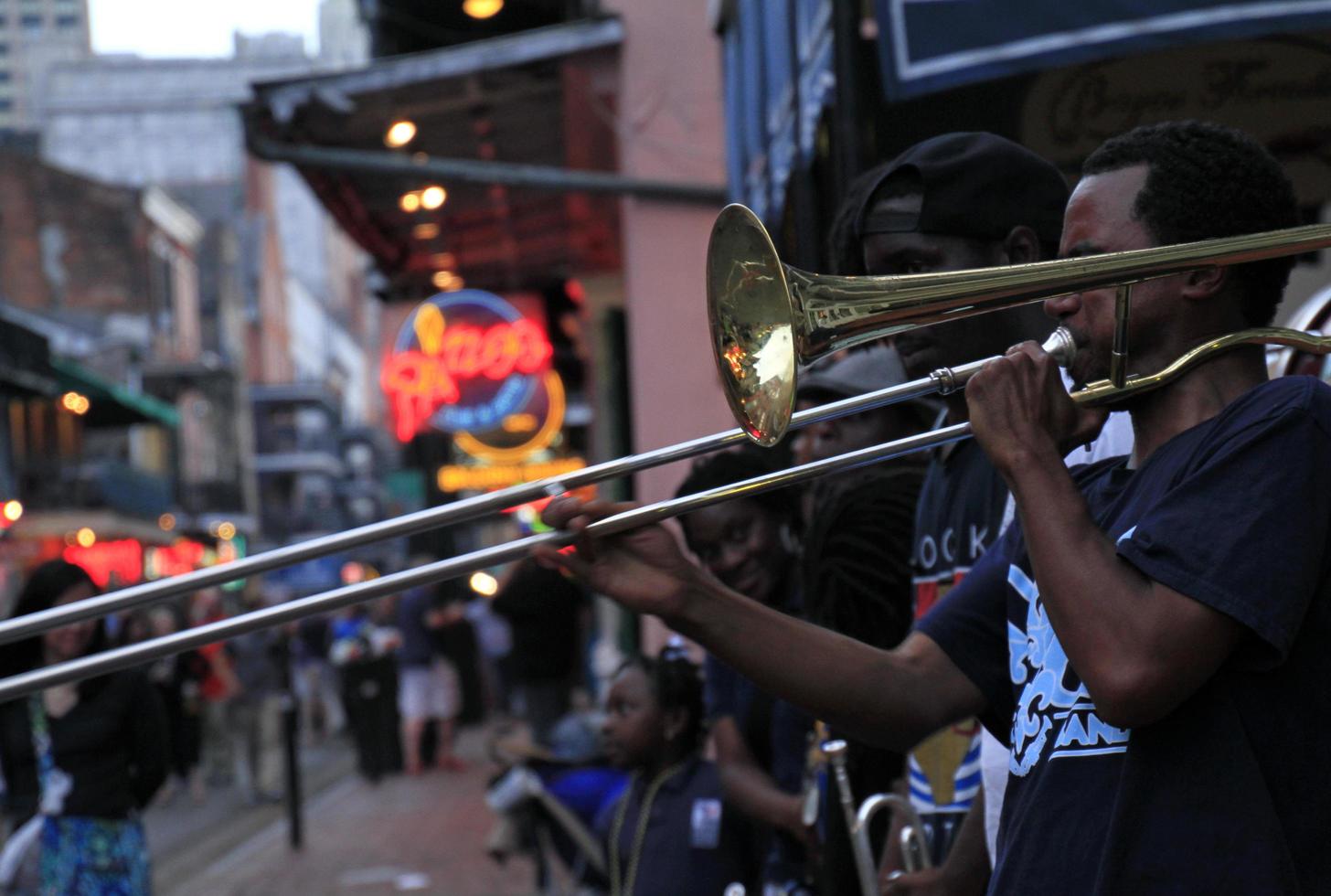 12 de abril de 2015 - nueva orleans, luisiana, estados unidos - músicos de jazz actuando en el barrio francés de nueva orleans, luisiana, con multitudes y luces de neón en el fondo. foto