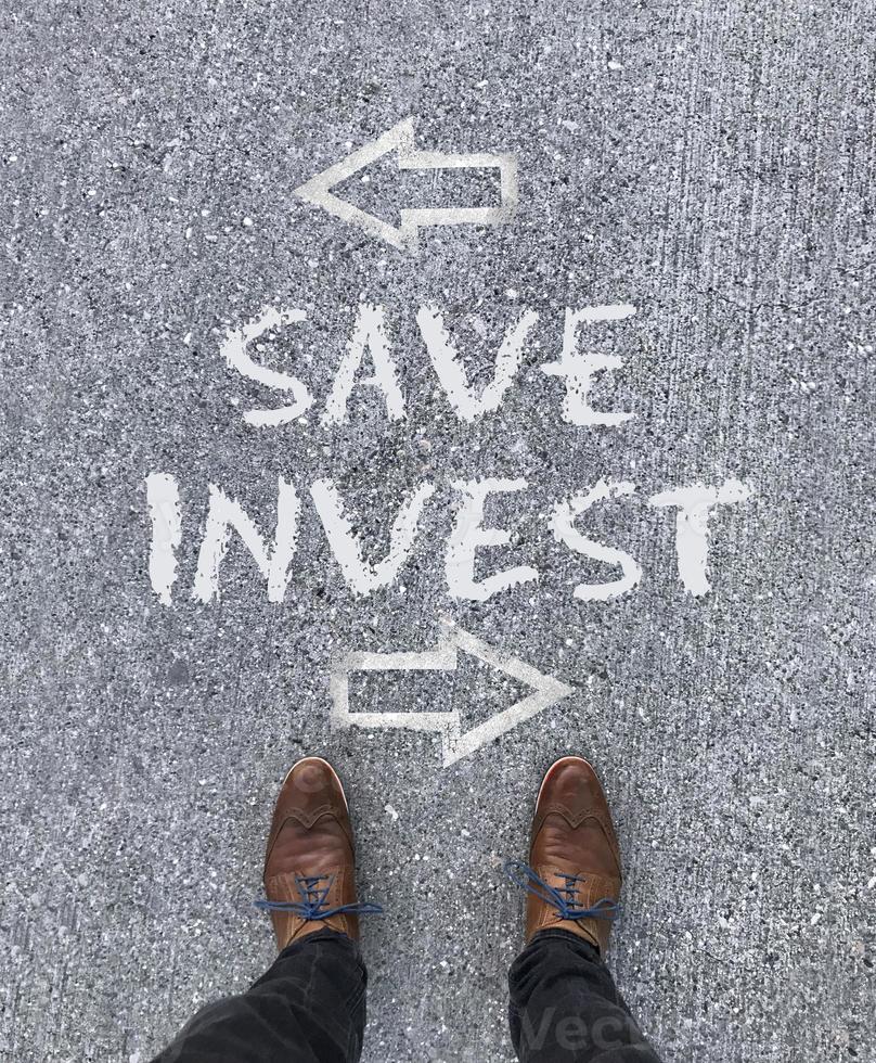 Top view on the words Save and Invest with arrows pointing left and right photo