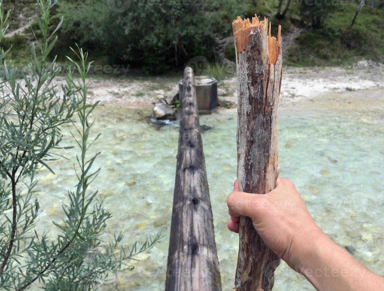 Overcoming obstacles - Hiker with hiking stick about to cross a dangerous bridge photo