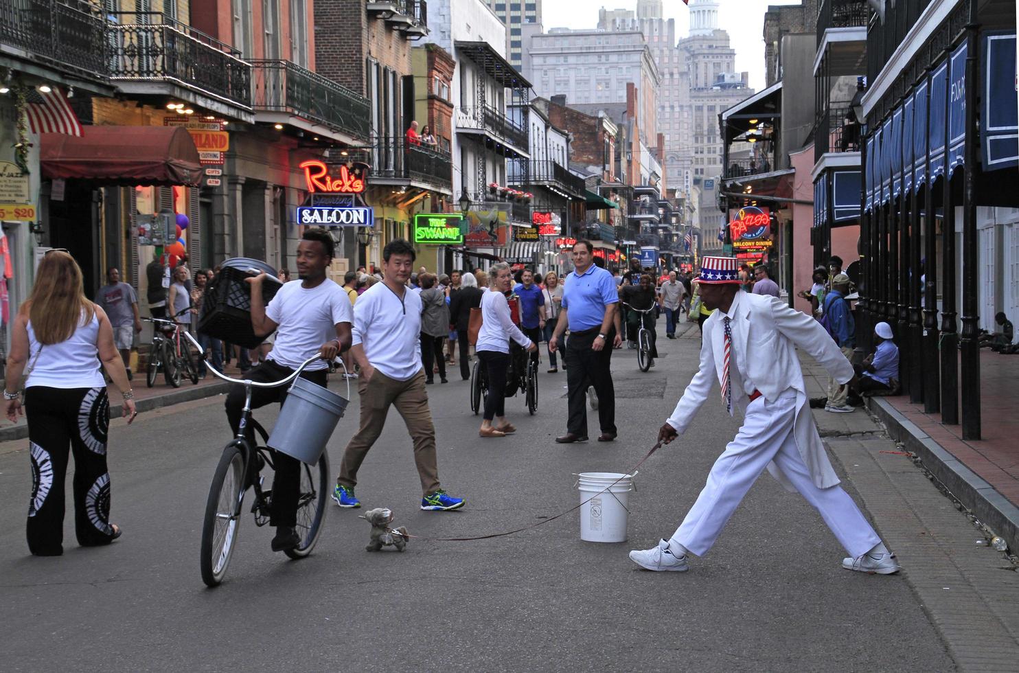 12 April 2018 - New Orleans, Louisiana, United States - Street artist during his performance in the French Quarter of New Orleans, Louisiana, with crowds and neon lights in the background. photo