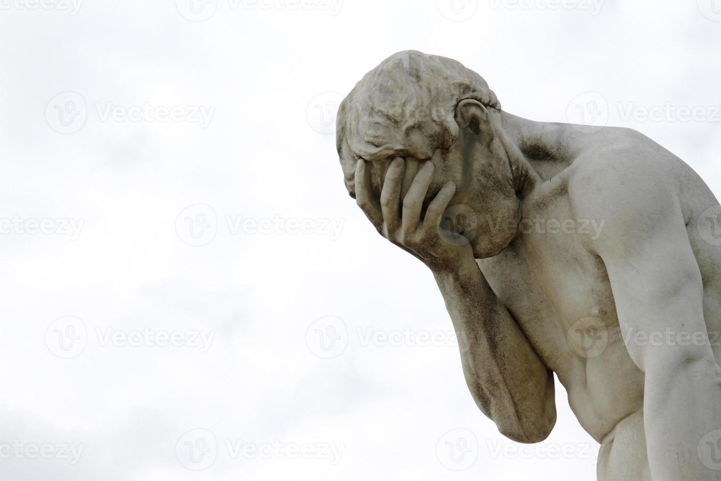 Statue with its head in its hand in Paris, France photo