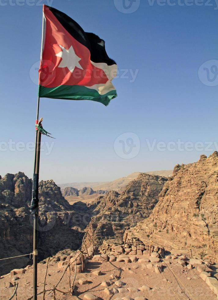 bandera nacional de jordania en el accidentado paisaje de petra, jordania foto