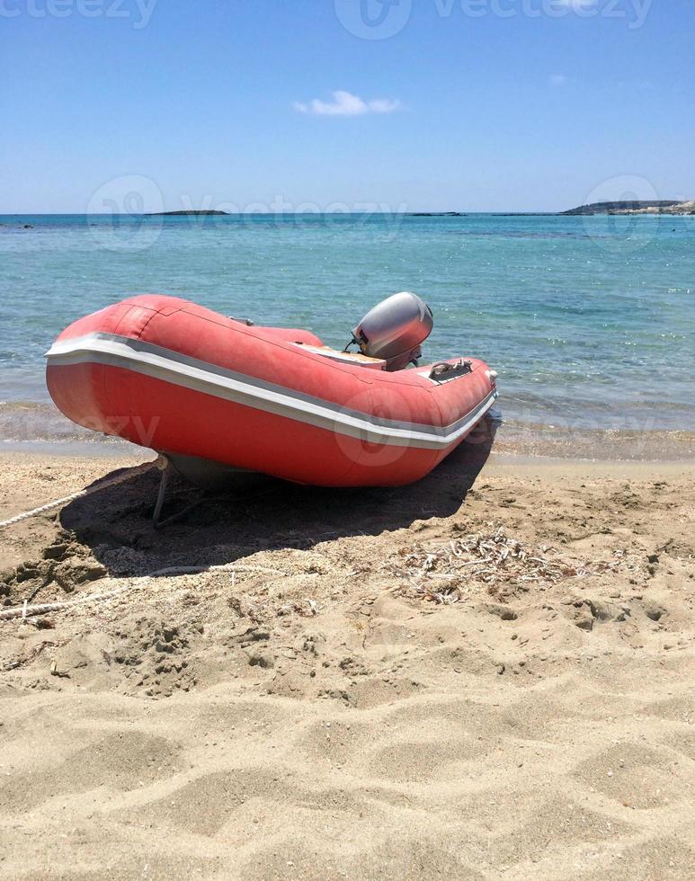 Red boat in front of the clear water at Elafonisi, Crete, Greece photo