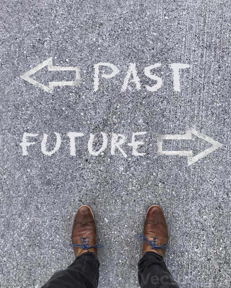 Man standing in front of two arrows and the words Past and Future photo