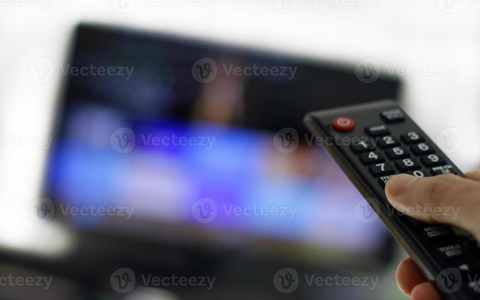 Remote control and screen - binge watching the favorite TV show photo