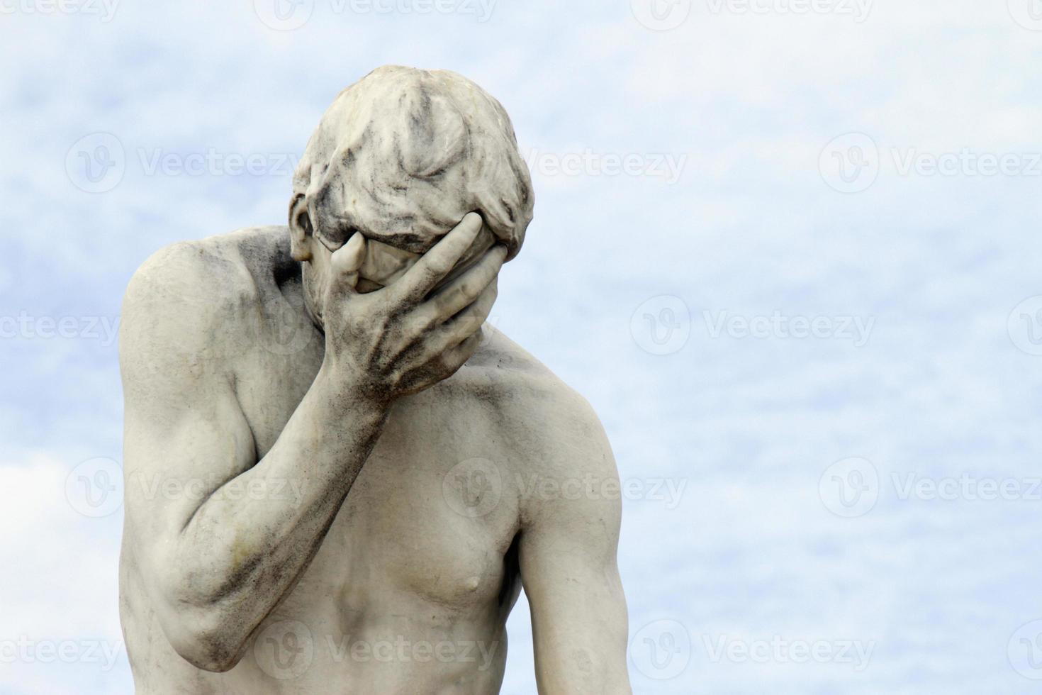 Statue with its head in its hand in Paris, France photo