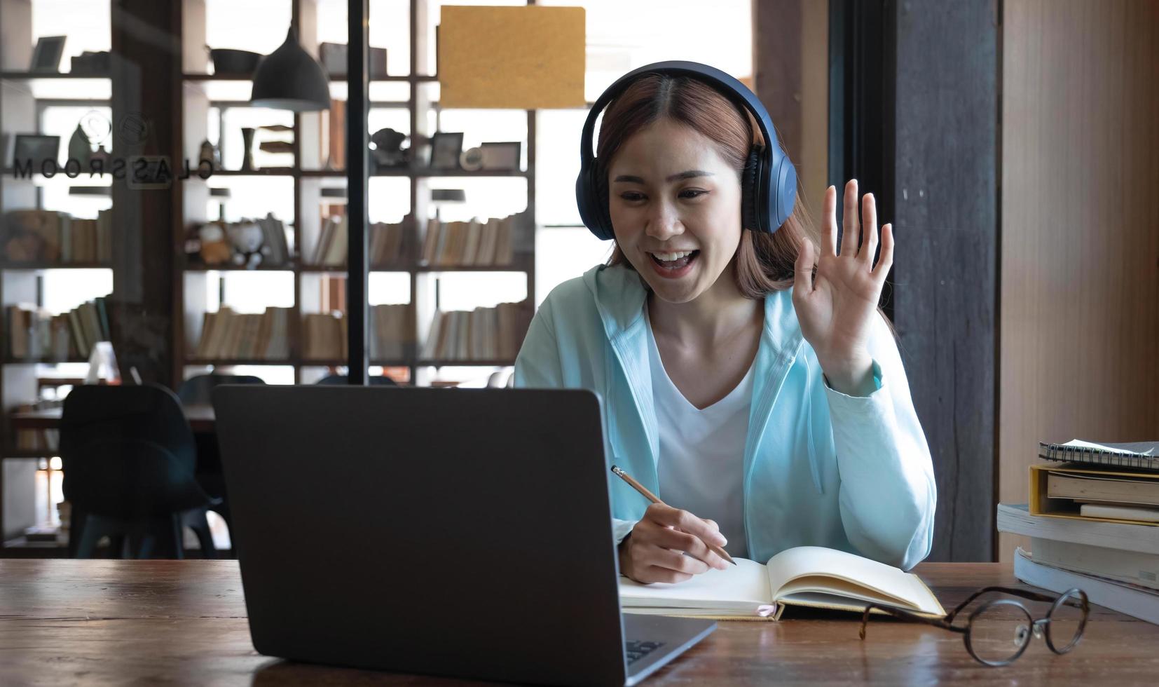 estudiante asiática en línea, clase de aprendizaje, estudio en línea, videollamada, profesor de zoom, niña asiática feliz, aprende inglés en línea con una computadora portátil. foto