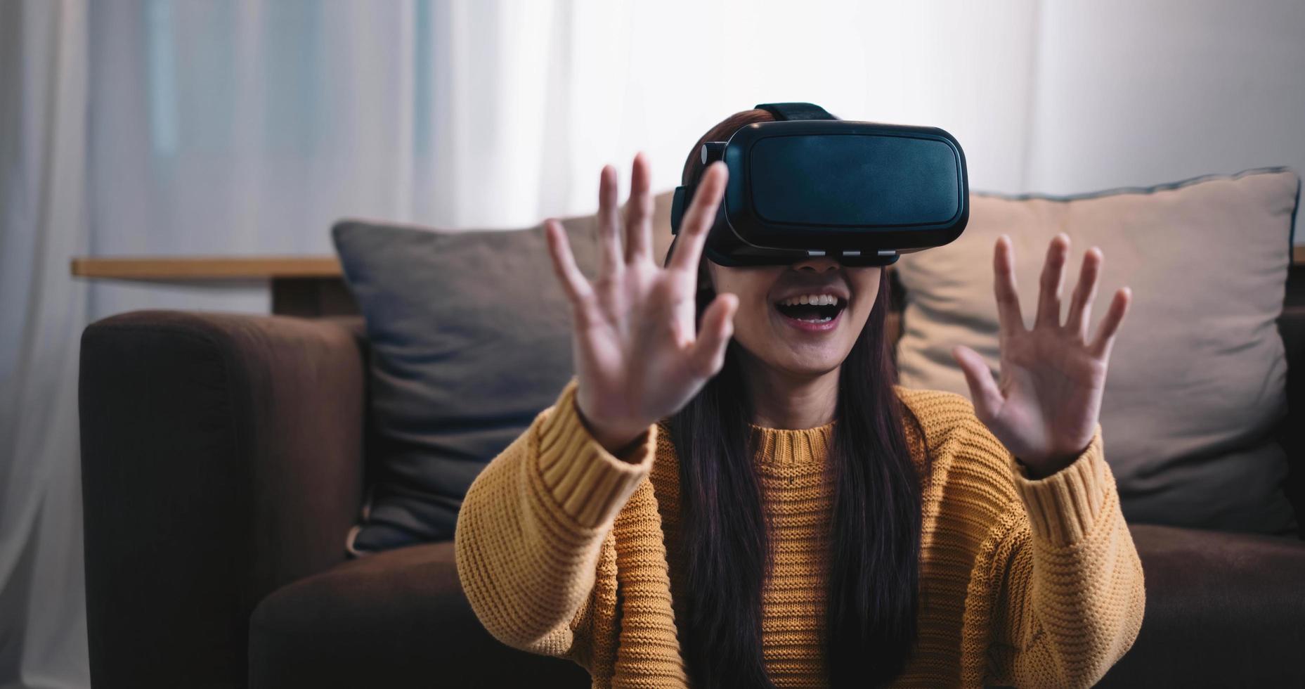 Asian woman play VR game for entertain at home, asian woman joyful in house on holiday. Happy woman playing metaverse VR technology concept. photo