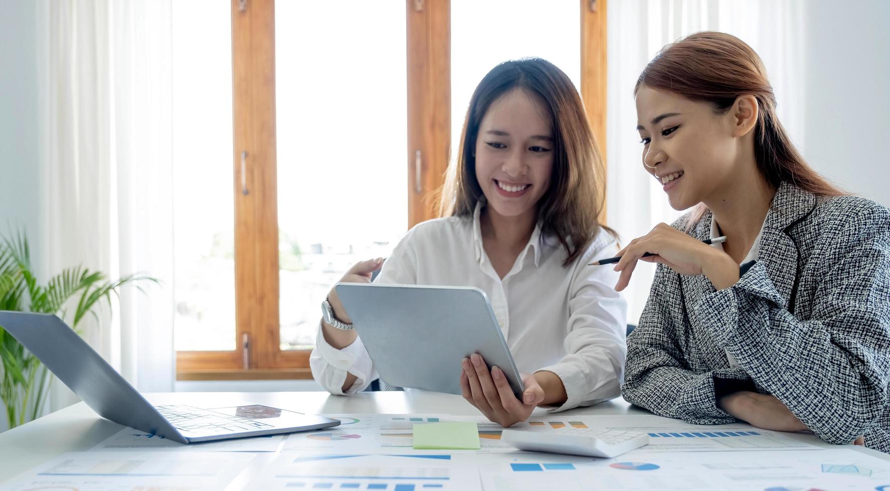 Two young asia business woman working together in office space photo