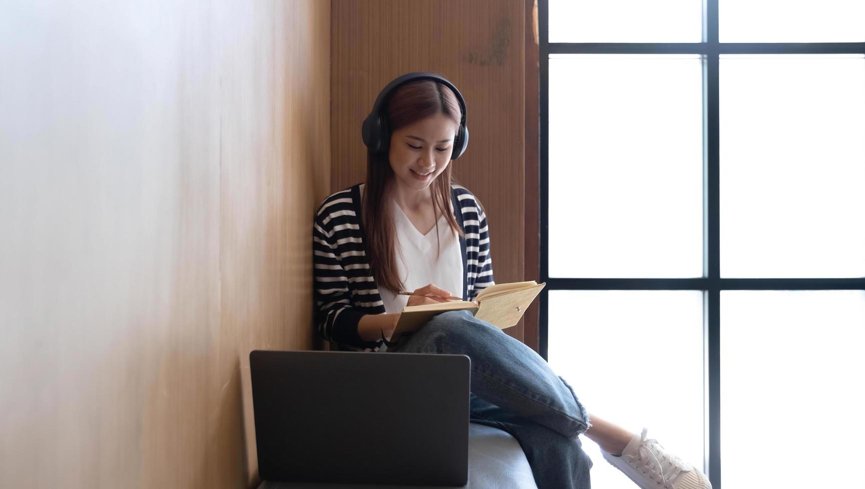 Young students use computers to study online. online education and learning Asian woman uses laptop technology while sitting at her desk and doing creative work. work from home concept photo