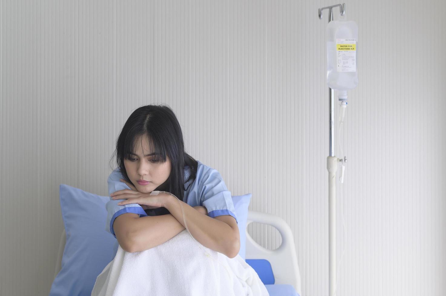 A despondent Asian woman patient. Following the doctor's declaration that the cancer was nearing the end of its course. photo