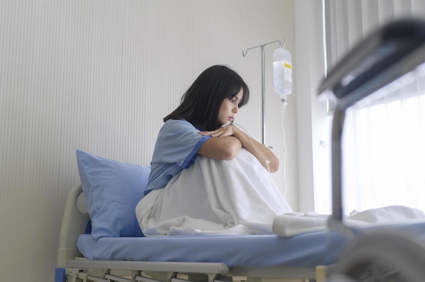 A despondent Asian woman patient. Following the doctor's declaration that the cancer was nearing the end of its course. photo