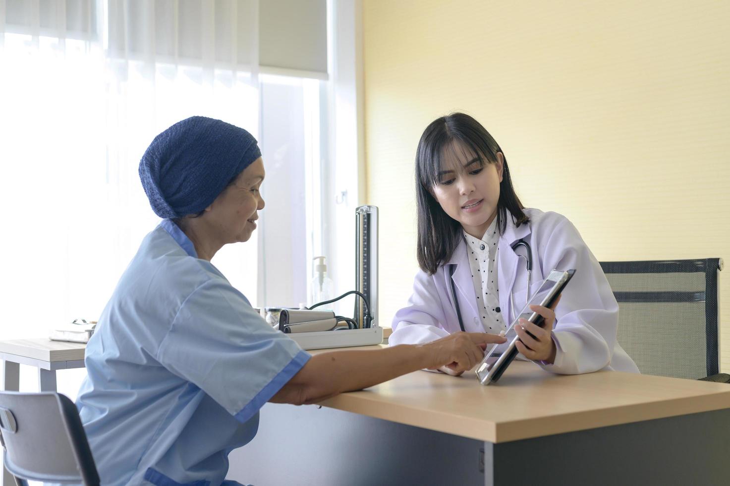 Cancer patient woman wearing head scarf after chemotherapy consulting and visiting doctor in hospital.. photo